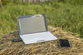 laptop with modem is on the the phone next to a haystack at sundown Royalty Free Stock Photo