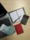 Laptop , money ,passport, pen,  calculator ,desk ,notebook with  blank pages Royalty Free Stock Photo