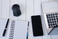 Laptop with mouse, notebook, pen and smartphone on white wooden table. Business concept Royalty Free Stock Photo