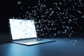Laptop with multipe particles flow coming out from the glowing white screen on a black background, corner view. Data and Royalty Free Stock Photo