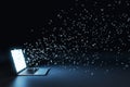 Laptop with multipe particles flow coming out from the glowing white screen on a black background. Data and information concept Royalty Free Stock Photo