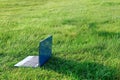 Laptop on natural green grass background. Freelance concept, work and study outside. Copy space Royalty Free Stock Photo
