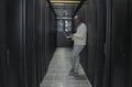 Laptop, network and data center with IT black man for research, engineer working in dark server room. Computer Royalty Free Stock Photo