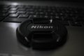 Laptop and Nikon lens cap