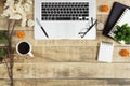 Laptop, notebook, diary and coffee on wood background.