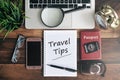 Laptop, notebook, smartphone, passport, compass, magnifying glass and clock with TRAVEL TIPS word