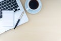 Laptop, notepad, fountain pen and cup of coffee on wooden background