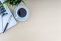 Laptop, notepad, fountain pen, decorative plant and cup of coffee on wooden background