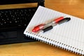 A laptop with a notepad and two pens Royalty Free Stock Photo