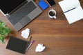 Laptop with office supplies, crumpled paper, green plant and hot black coffee with smoke on vintage grunge wooden desk background Royalty Free Stock Photo