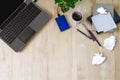 Laptop with office supplies, crumpled paper, green plant and hot black coffee with smoke on vintage grunge wooden desk background Royalty Free Stock Photo