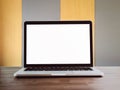 The laptop open a blank white screen on brown wooden desk. The background is yellow and gray alternately beautiful. Royalty Free Stock Photo