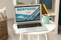 Laptop with open page for mortgage loan payment on table