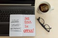 Laptop, and notebook with the words `stop smart working, go back to office`. Royalty Free Stock Photo