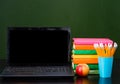Laptop and pile of books near empty green chalkboard. Sample for Royalty Free Stock Photo