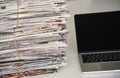 Laptop and pile of newspapers