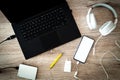 Laptop with a portable disk with connected headphones and a smartphone on the desk. place of relaxation or work. white phone scr