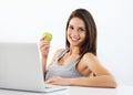 Laptop, portrait and woman nutritionist with apple in studio for wellness, diet or eating plan on white background