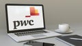 Laptop with PricewaterhouseCoopers PwC logo on the screen. Modern workplace conceptual editorial 3D rendering