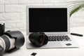 Laptop and professional photographer`s equipment on table indoors. Royalty Free Stock Photo