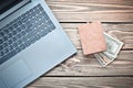 Laptop and a purse with money on a wooden table. The concept of online work on the Internet, freelancing. Royalty Free Stock Photo