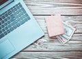 Laptop and a purse with money on a wooden table. The concept of online work on the Internet, freelancing. Top view. Royalty Free Stock Photo
