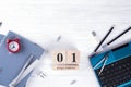 Laptop, red alarm clock and supplies, wooden calendar with date 1st September. on white desk. Back to school concept. Royalty Free Stock Photo