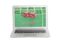 Laptop with red dice on a game table in casino on screen Royalty Free Stock Photo