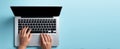 The laptop resting on a light blue workspace with hands typing actively on the keyboard..AI generated image Royalty Free Stock Photo