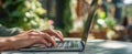 The laptop resting on a table in a vibrant outdoor workspace..AI generated image Royalty Free Stock Photo