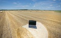 Laptop on rolled bale on field