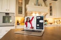 Laptop screen on table with biracial girl raising hand while studying online and messages