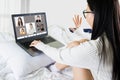 Laptop screen view over shoulder asian woman talking about work,sitting in bedroom make video call have distant communication