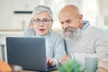 Laptop, senior couple and typing in home, internet browsing or social media in house. Computer, retirement and man and Royalty Free Stock Photo