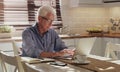 Laptop, senior man and working in kitchen on retirement plan, monthly budget and expenses in home. Typing, technology Royalty Free Stock Photo