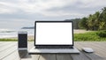 Laptop, smartphone and mouse on wooden deck with tropical beach background computer Royalty Free Stock Photo