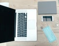 Laptop, smartphone and protective mask on the office Desk Royalty Free Stock Photo