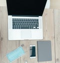 Laptop, smartphone and protective mask on the office Desk Royalty Free Stock Photo