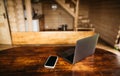 Laptop with smartphone on a wooden table in a wooden house. Work in country wooden house concept. Background Royalty Free Stock Photo