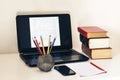 Laptop, stack of books, notebook, smartphone in office background for education learning concept Royalty Free Stock Photo