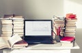 Laptop, stack of books, notebooks and pencils on white table, education office concept background Royalty Free Stock Photo