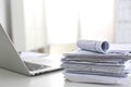 Laptop with stack of folders on table white background Royalty Free Stock Photo