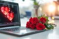 laptop standing at workplace in office,on monitor of which red heart is painted,next to it lies bouquet of scarlet roses concept