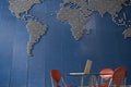 Laptop on table in empty office with world map on wall Royalty Free Stock Photo