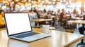 Laptop on table, a glimpse into the modern blend of work and leisure in restaurant setting Royalty Free Stock Photo