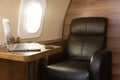 Laptop on the table in the interior of a private jet. Flying first class. Royalty Free Stock Photo