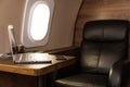 Laptop on the table in the interior of a private jet. Flying first class. Royalty Free Stock Photo