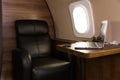 Laptop on the table in the interior of a private jet. Flying first class. Royalty Free Stock Photo