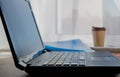 Laptop on the table. Window in the background. Work from home. Office equipment in the workplace. Conceptual image of office work Royalty Free Stock Photo