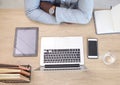 Laptop, tablet and phone with a business man sitting at his desk in the office at work from above. Flatlay, computer and